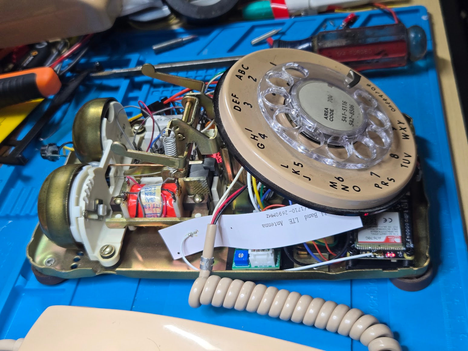 Side view beneath the raised rotary dial showing the flexible LTE antenna tucked into the available space