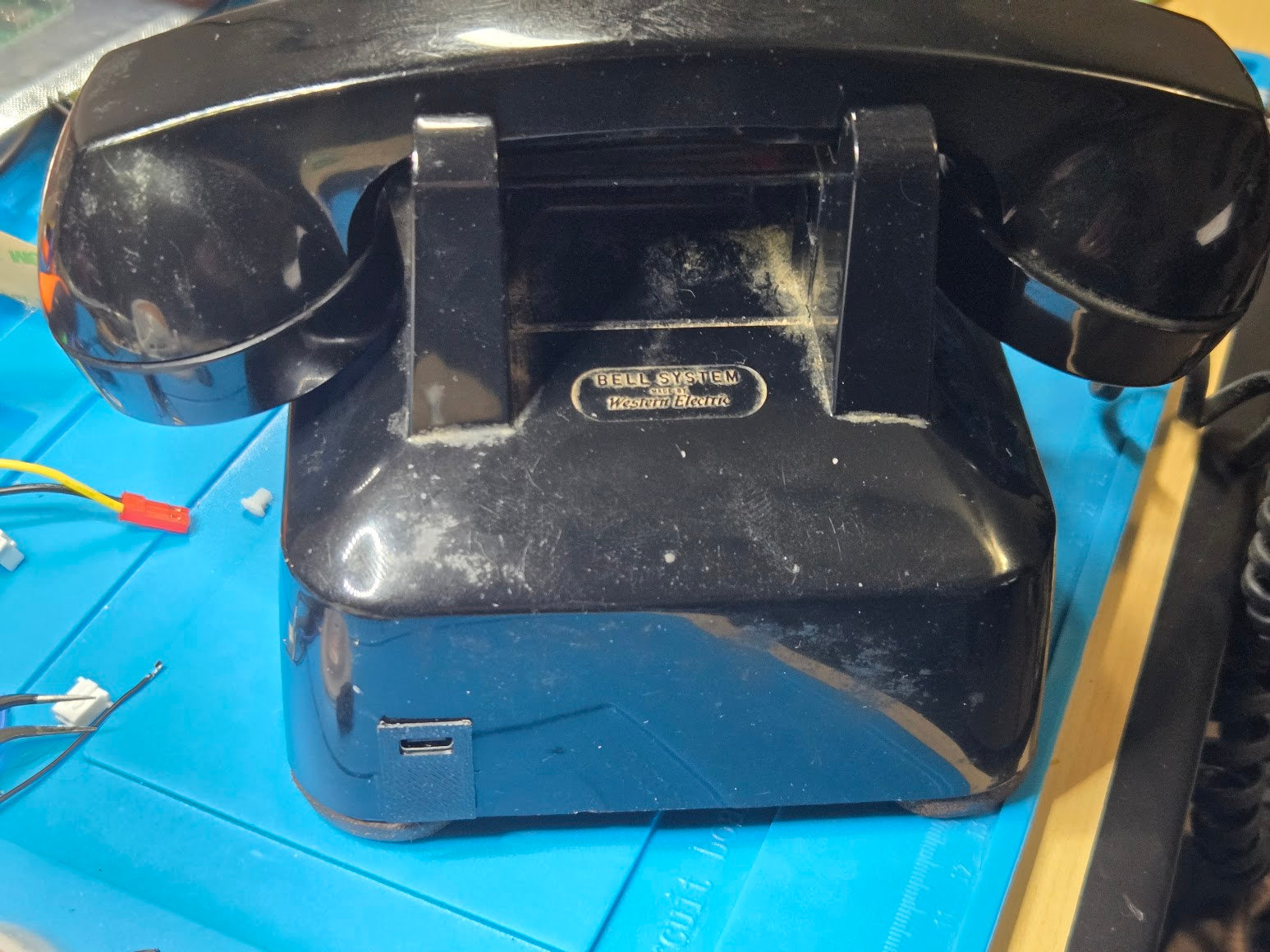 Rect R3 USB-C charging insert fitted in the modular-jack opening of a black telephone